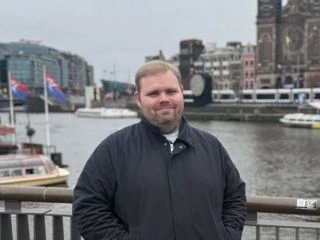 Person by a river in a city setting.